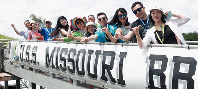 Greater China Sales Leaders of Nu Skin pose for a picture on their way onto the USS Missouri.